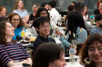 Smiling students sitting at tables enjoying themselves at the Spirit of Sussex Award celebration event