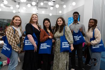 Spirit of Sussex Award participants holding branded blue tote bags