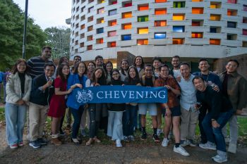 Group of Chevening scholars outside the Meeting House holding a banner