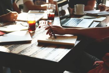 People working around a table with drinks and laptops