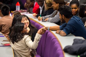 Two students shaking hands in a lecture theatre