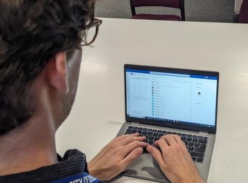 Man typing on a laptop displaying the Teams Calling screen