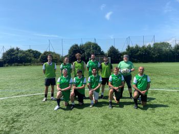 people wearing football clothes standing together on a football pitch