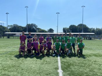 people wearing football clothes standing together on a football pitch