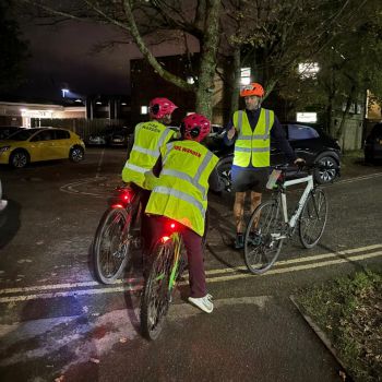 three people with bikes in hi-vis jackets