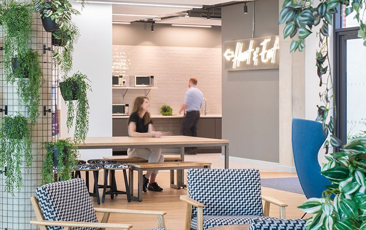 Chairs and tables with a light up sign saying heat and eat in the background