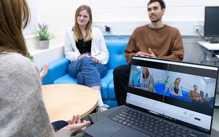A researcher talking to participants while recording their facial expressions