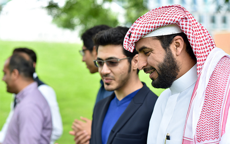 A group of male Middle Eastern students walking and talking on Sussex campus