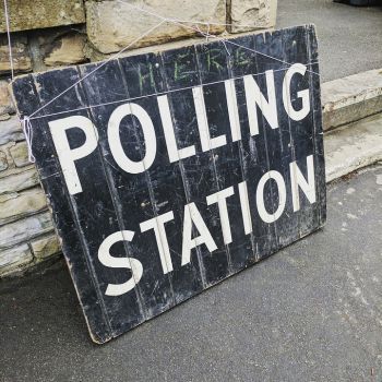 Image showing polling station sign up against railings