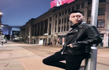 Student Ambassador, Duc Hieu Nguyen, leaning against a lamp post in London at night