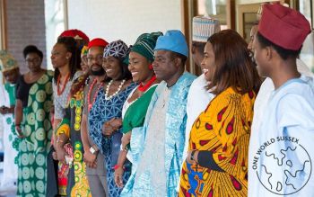 Line of twelve men and women dressed in traditional Nigerian clothes