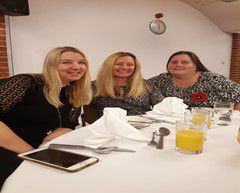 Three smartly dressed women at a lunch table