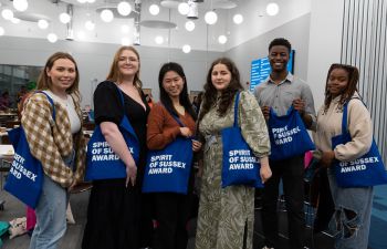 Spirit of Sussex Award participants holding branded blue tote bags