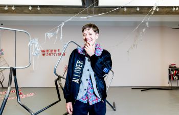 Jesse Darling, winner of the Turner Prize 2023 smiling in front of his exhibition