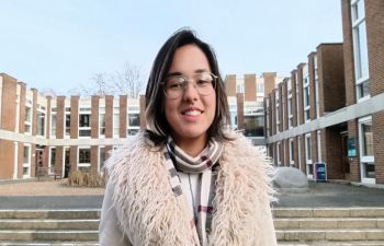 Digital Media Creator, Grace, standing in front of campus buildings