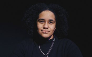 A headshot of Subira Joy on a black background