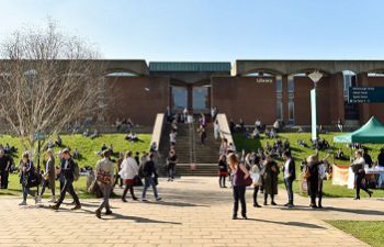 Library exterior and steps with many people in foreground