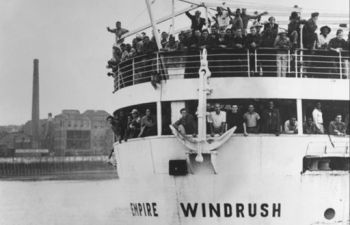 Black and white photograph of HNT Empire Windrush with people aboard
