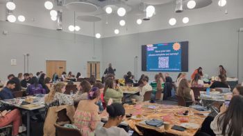 Event attendees seated at long tables, engaging in discussions and activities.