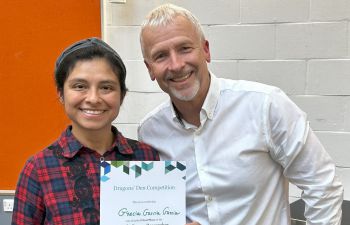 Grecia Garcia Garcia is presented with a certificate for winning the ECR Dragons' Den competition. She poses with Peter Lane, both smiling at the camera.