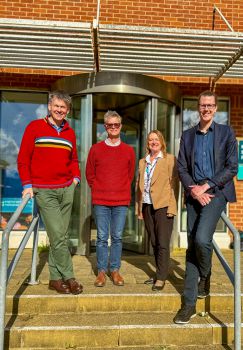 A photo of four of the SCRC team stood outside the research building on the steps smiling