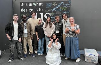 Dr Claire Potter [far right] and eight students who presented at New Designers this year in front of a poster that reads 