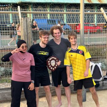 4 staff members holding a trophy