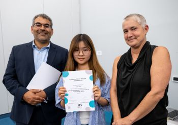 Pro-Vice Chancellor for Global and Civic Engagement, Robin Banerjee and Pro-Vice Chancellor for Education and Students, Kate O’Riordan, stand either side of IJRA student who they have presented a certificate to.