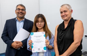 Pro-Vice Chancellor for Global and Civic Engagement, Robin Banerjee and Pro-Vice Chancellor for Education and Students, Kate O’Riordan, stand either side of IJRA student who they have presented a certificate to.