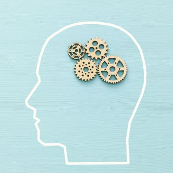 A silhouette of a head with wooden cogs inside it