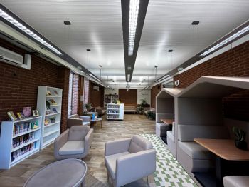 The Wellbeing Area. There is comfy seating, study booths on one side and bookcases.