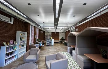 The Wellbeing Area. There is comfy seating, study booths on one side and bookcases.