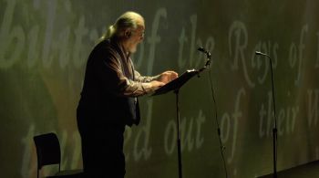 Professional singer, older man, on stage, portraying role of John Milton (poet)