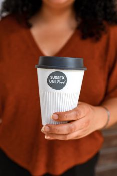 A woman holding one of the new returnable cups