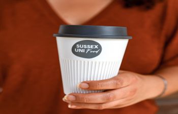 A woman holding one of the new returnable cups