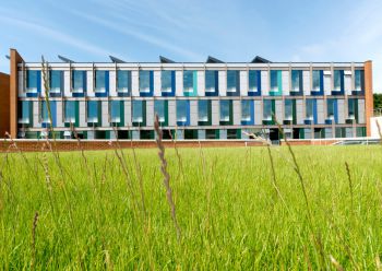 A beautiful tall building with green grasses in the front