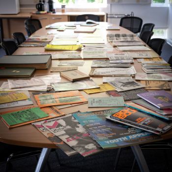 A collection of books and pamphlets from Library Collections displayed on a large table