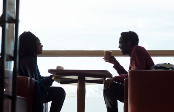 Two student in profile sit at a table.