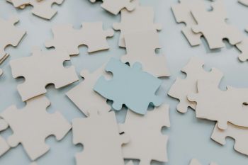 An assortment of jigsaw pieces in a close up photo, with one overturned and a different colour