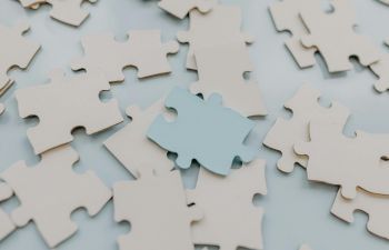 An assortment of jigsaw pieces in a close up photo, with one overturned and a different colour