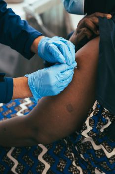 A woman's arm being vaccinated by a medic