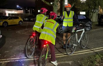 three people with bikes in hi-vis jackets