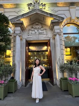 Lady wearing a long white dress in front of a hotel entrance