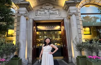 Lady wearing a long white dress in front of a hotel entrance