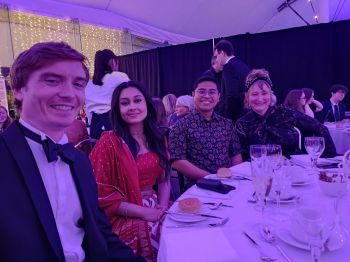 Three students and one staff member sat at Awards dinner table