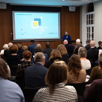 Prof Victoria Grace Richardson-Walden speaks at a podium in front of an audience at the launch of the Landecker Digital Memory Lab