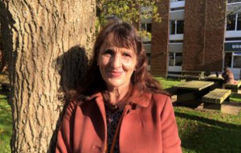 Jacqui Bealing on campus in front of a tree