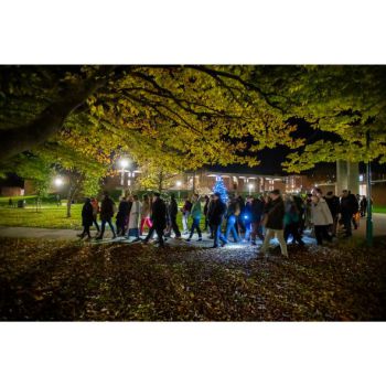 Singing while walking through campus. lit by lanterns