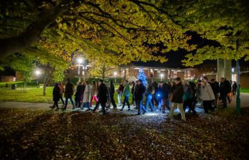 Singing while walking through campus. lit by lanterns