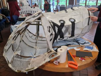 A large paper shoe sculpture under construction